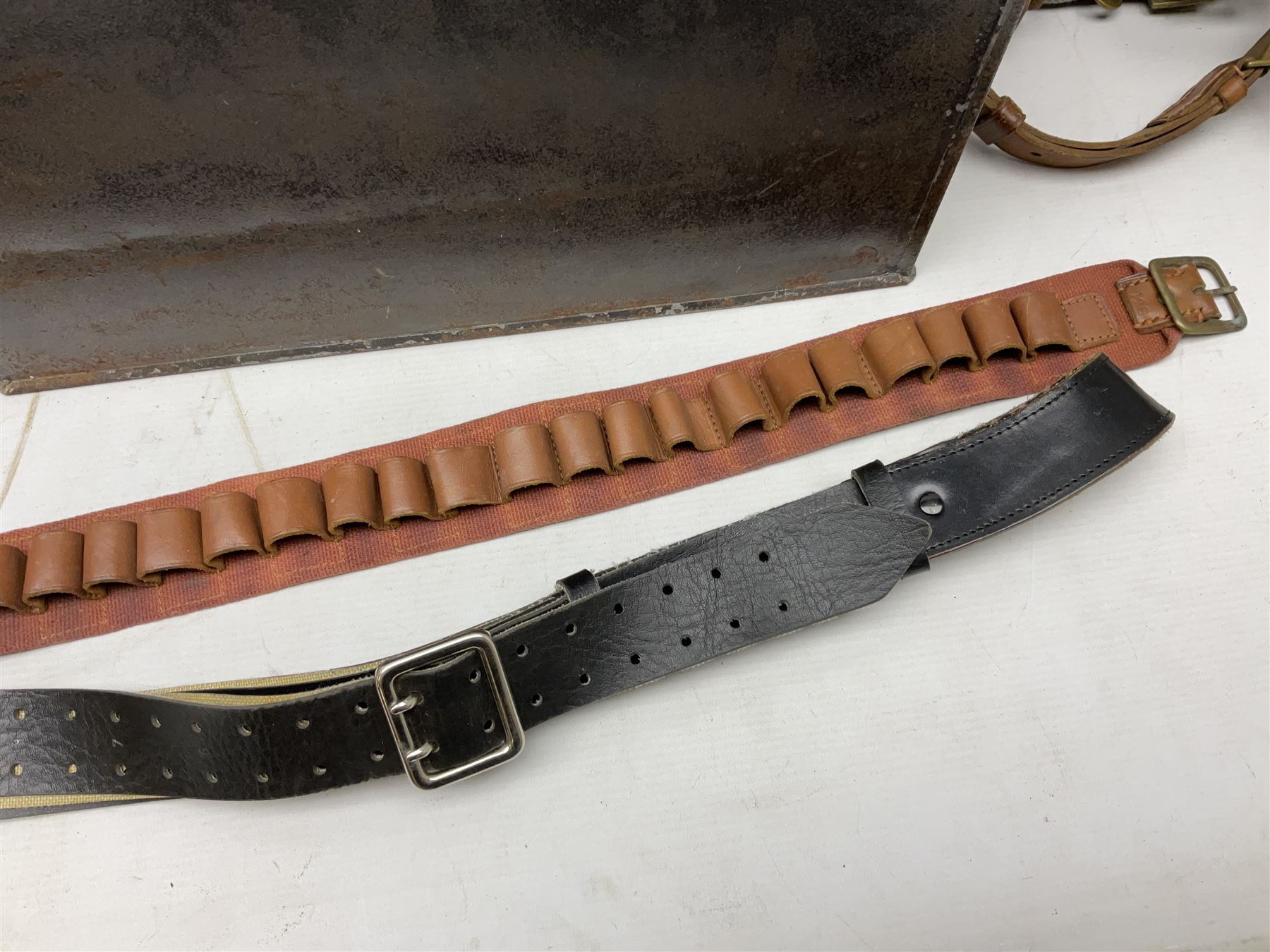 Assorted militaria including ten leather or canvas cartridge and other belts, maroon beret with 17th Lancers cap badge, modern bullet mould, leather and brass shot flask, two knives, shell cases, boomerang etc; in tin deed box