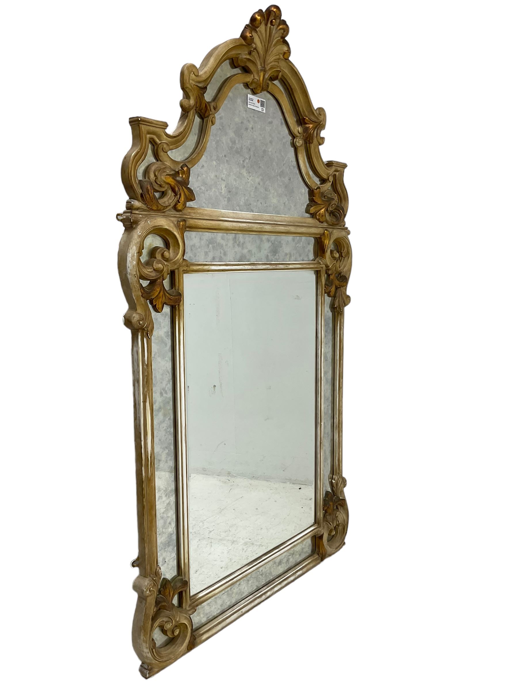 Victorian design parcel gilt wall mirror, shaped cresting with foliate cartouche pediment, decorated with C-scrolls and scrolled foliage, moulded frame with segmented mirror plates