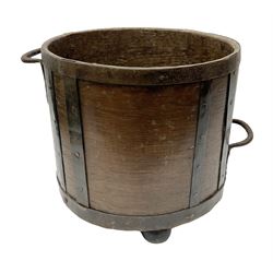 19th Century mahogany iron banded bucket, the cylindrical body with twin handles and raised upon three bun feet, H29.5cm