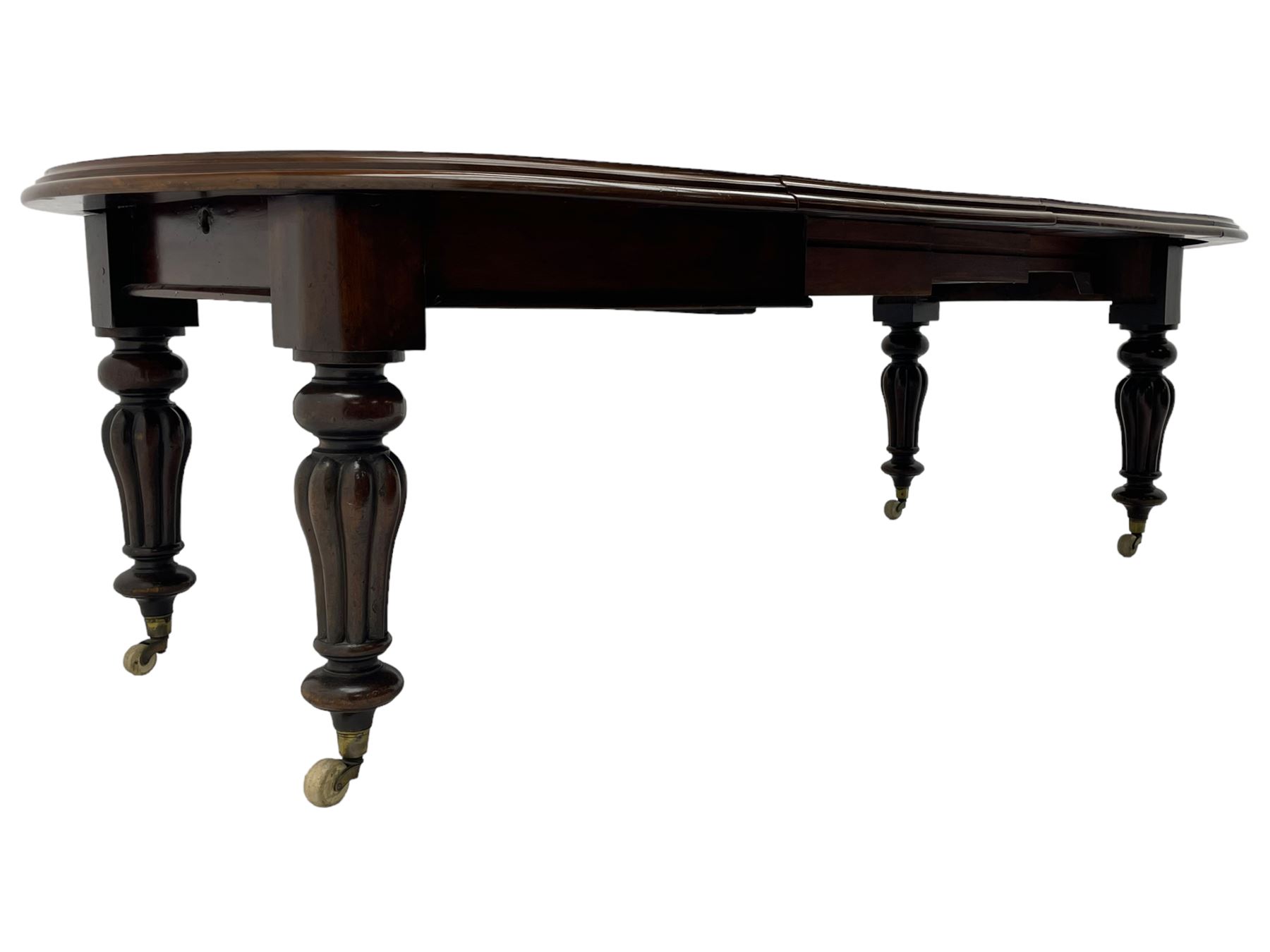 Victorian mahogany extending dining table, circular telescopic extending top with moulded edge, two additional leaves, on turned and lobe carved supports with brass and ceramic castors 