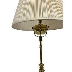 Edwardian brass plated copper standard lamp, telescopic stem on lobe moulded circular base with three projecting paw feet, with cream shade