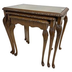 Mid-20th century figured walnut nest of three tables, foliate carved edge and glass inset top, cabriole supports with acanthus moulded knees