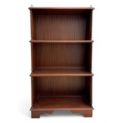 Mid-20th century mahogany open bookshelf, the rectangular top with a brass balustrade gallery, over three shelves each supported by turned column uprights, on shaped apron base