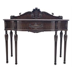 Early 20th century Hepplewhite style serving table, raised fleur-de-lis feather back with fluted detail and flower head mounts, the shaped top with carved foliate edge over single central drawer with applied urn motif, turned and reeded acanthus supports with recessed castors