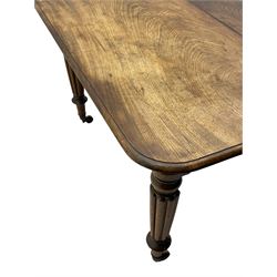 Early 19th century figured mahogany extending dining table, the rectangular top with moulded edge and rounded corners, pull-out action with three additional leaves, raised on turned and lobe carved supports with brass cup castors