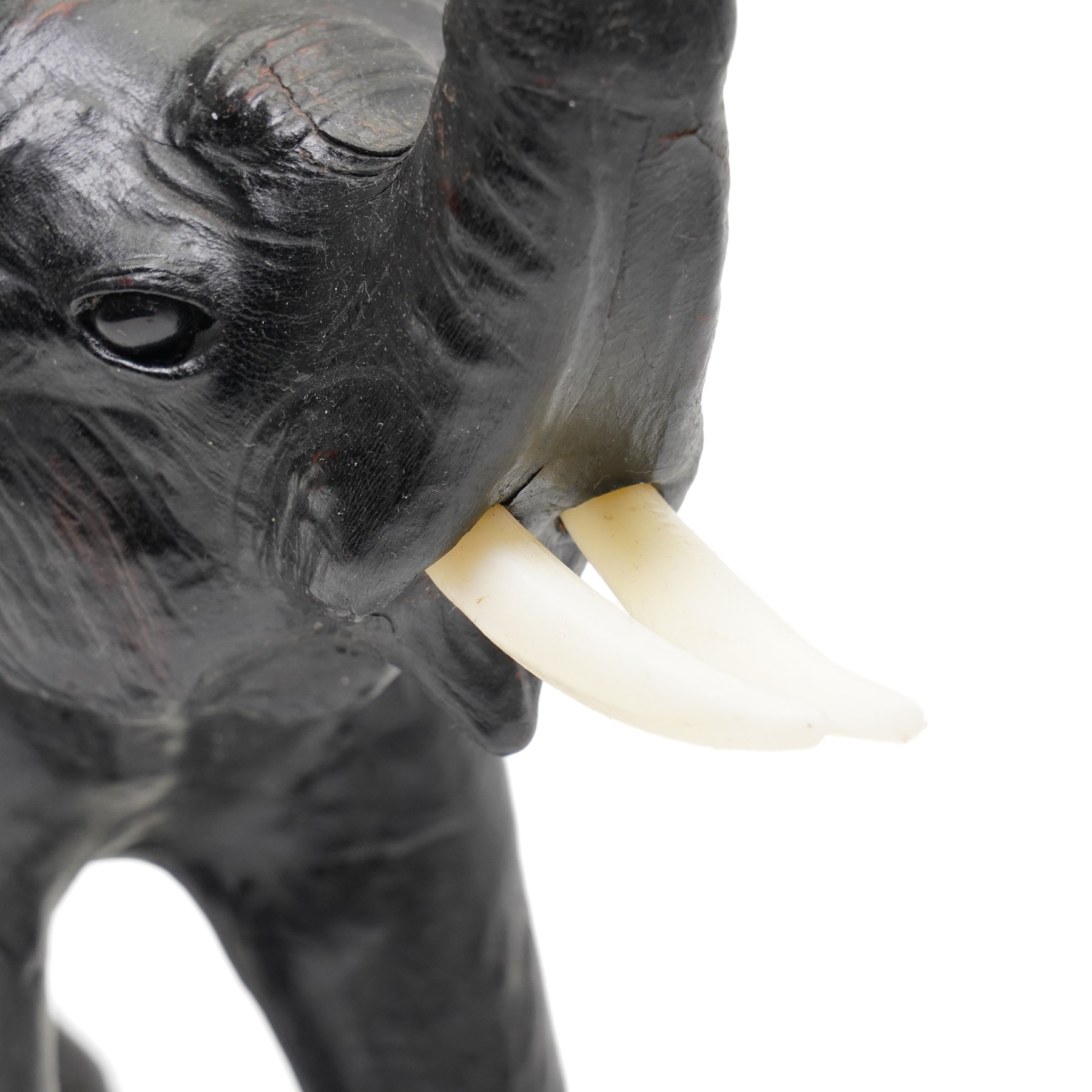 In the style of Liberty & Co - pair of 20th century ebonised papier mache elephants 