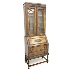 Early 20th century oak bureau bookcase, raised display cabinet enclosed by glazed doors, fall front above two drawers, turned supports joined by plain stretchers