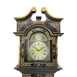 20th century 8-day chain driven black lacquered longcase clock - with a swans neck pediment and break-arch hood door, fully glazed trunk door displaying brass cased weights and pendulum, case sides, hood and plinth profusely decorated in gold relief and chinoiserie figures, brass break arch dial with an etched centre and silvered chapter ring, German two train movement striking the hours and half hours on two gong rods. With weights and pendulum.

