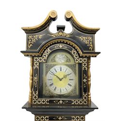 20th century 8-day chain driven black lacquered longcase clock - with a swans neck pediment and break-arch hood door, fully glazed trunk door displaying brass cased weights and pendulum, case sides, hood and plinth profusely decorated in gold relief and chinoiserie figures, brass break arch dial with an etched centre and silvered chapter ring, German two train movement striking the hours and half hours on two gong rods. With weights and pendulum.
