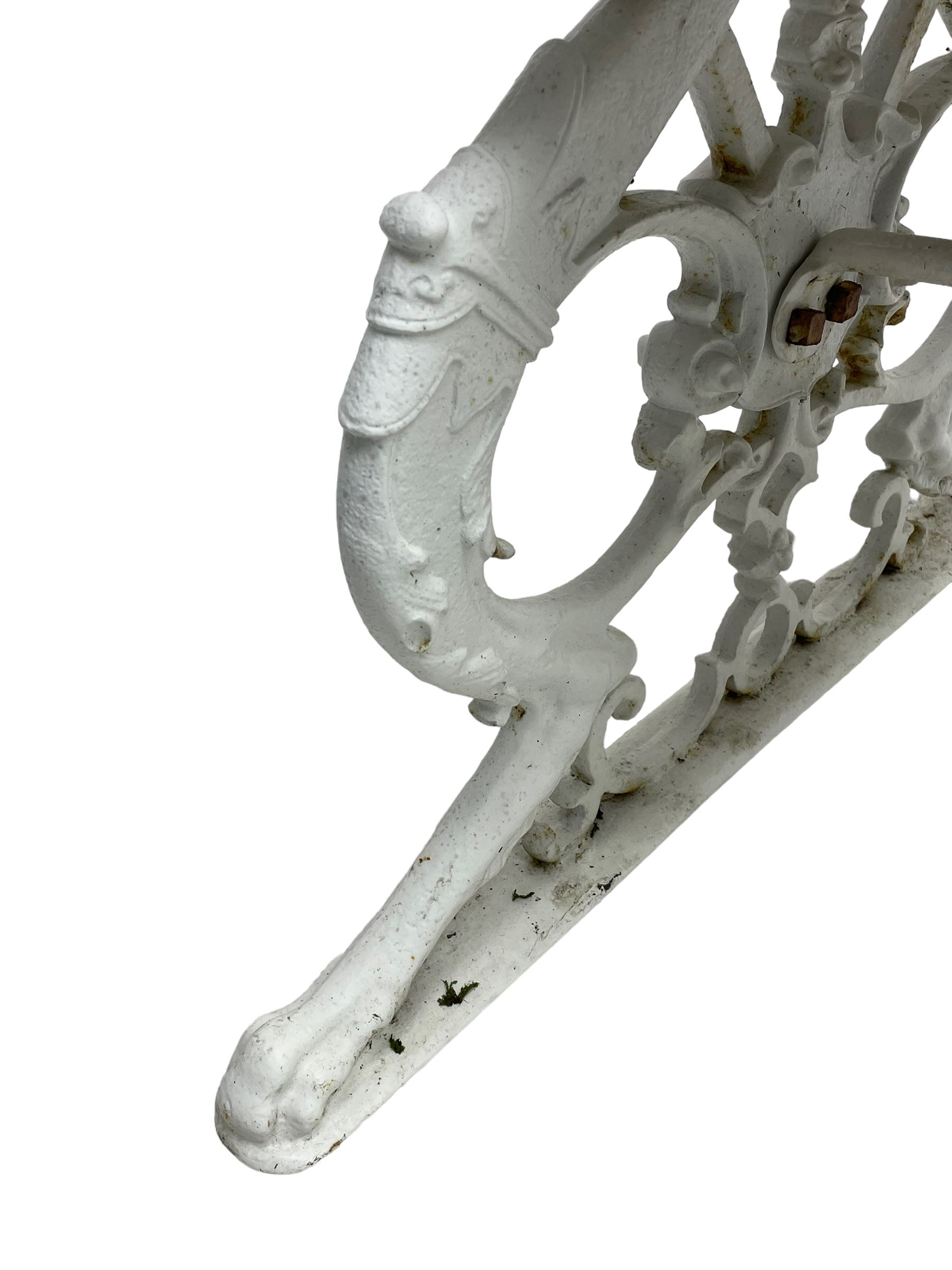 Late 19th century white painted cast iron and wood slatted garden bench, the bench ends in the form of S-scroll mythical beasts with paw feet, central cartouche surrounded by extending trailing foliage, the back slats divided by scroll cast splats, central seat support 