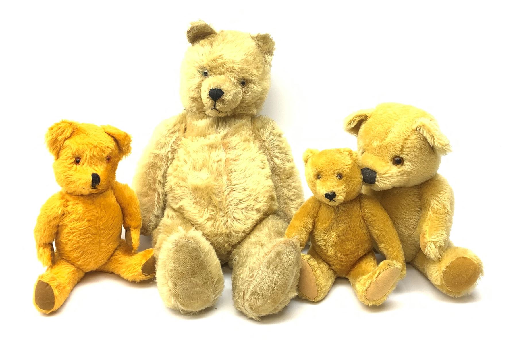 Four 1950s English/European teddy bears including an orange plush wind-up musical bear with swivel jointed head, glass type eyes, vertically stitched nose and mouth and jointed limbs with felt paw pads H19