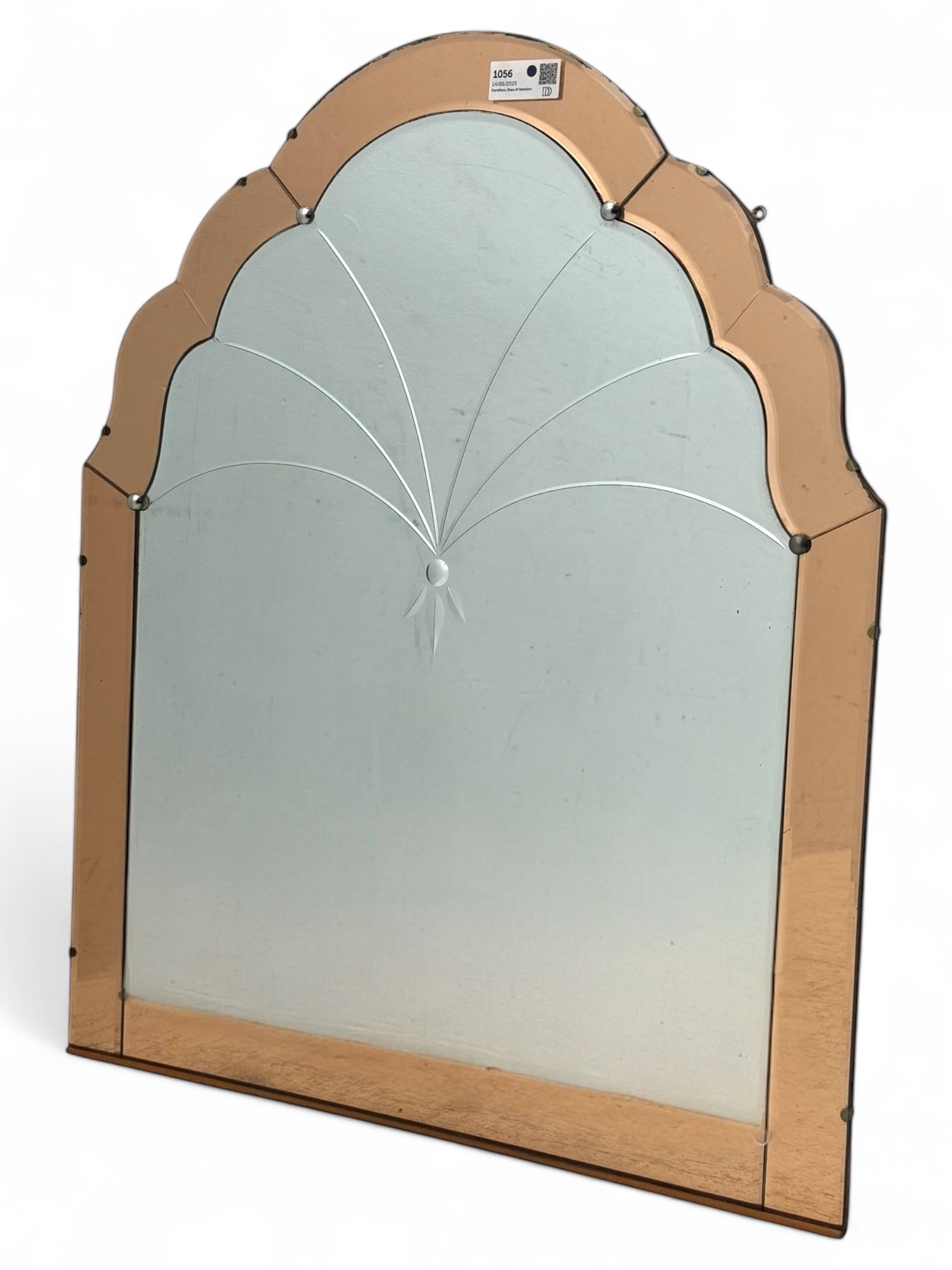 Frameless art deco mirror, scalloped copper tinted border central fan motif, bevelled edges with decorative screw caps