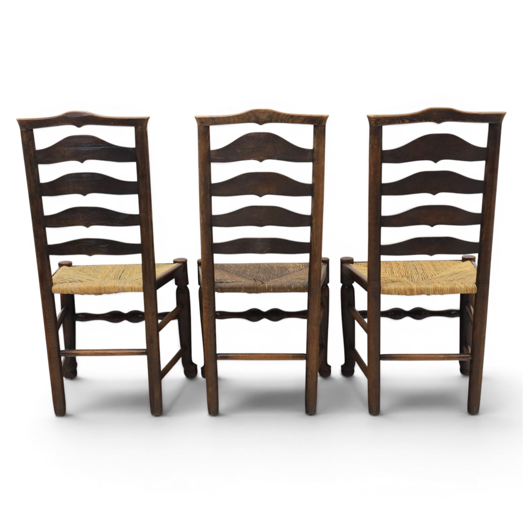 Set of seven (6+1) Georgian design country elm Lancashire dining chairs, ladder backs with rush seats, turned front leg stretcher on pad feet, height of seat 44cm, complete with fitted tie on cushions