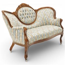 Victorian mahogany double cameo back sofa, the shaped back with central button upholstered oval panel and carved foliate crest above upholstered arms and seat, raised on cabriole legs terminating in castors