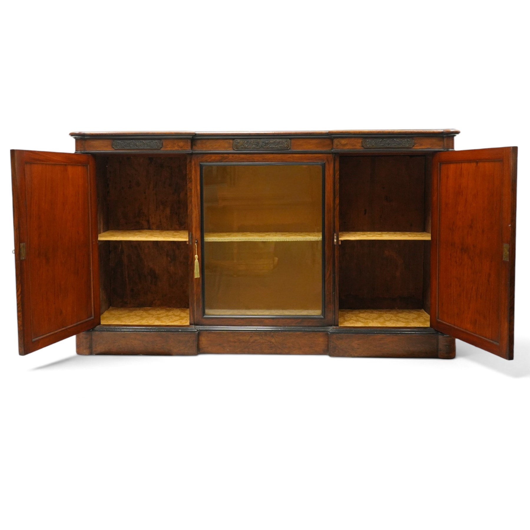 Lamb of Manchester (est. 1843) - Victorian Aesthetic Movement inlaid figured and burr walnut inverted-breakfront credenza, the shaped rectangular top with ebony banding and boxwood stringing, the frieze applied with bronze mounts decorated with foliate and scroll motifs, fitted with central glazed door flanked by panelled doors with central oval metal plaques depicting Classical Muses with lyre, the flanking canted uprights applied with caryatid maidens holding torches, acanthus terminal over skirted base