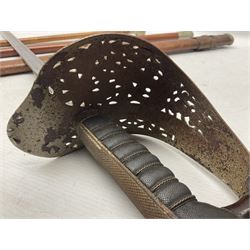 George V 1897 pattern Army Officer's sword by Henry Wilkinson Pall Mall London, the 82.5cm 'London Made' blade etched to both sides with Royal Crests and cyphers etc, pierced half-basket hilt with wire-bound fish skin grip and remains of leather knot strap; in leather covered field service scabbard L101cm overall; and two 14th Prince of Wales Own swagger sticks (3)