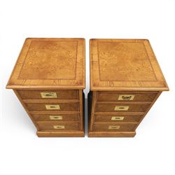 Pair of burr oak bedside tables with campaign brass handles, inlaid and crossbanded top, above four graduating drawers with cockbeaded edges, raised on a plinth base 