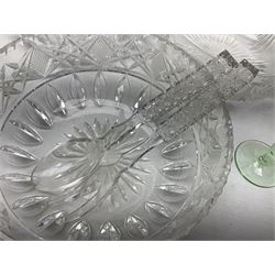 Quantity of glassware comprising three cut glass bowls with strawberry, fan and swags decoration, pair of servers with hobnail decoration handles, lidded decanter, jug and quantity of uranium glasses, tallest H30cm