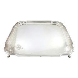 Early 20th century silver salver, of square form with shaped corners and moulded rim, with engraved monogram to one corner, upon four hoof feet, hallmarked Barker Brothers Silver Ltd, Birmingham 1938, 30cm, weight 39.28 ozt (1222 grams)