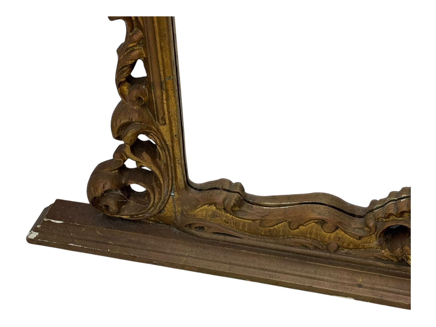 Victorian design gilt framed overmantel mirror, the arched and moulded frame adorned with scrolling foliate motifs and acanthus leaves, surmounted by a pierced cartouche, plain mirror plate, resting on a shaped base