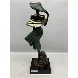 Durastone 'The Breeze' figure, modelled as a woman holding her dress on a stylised rocky base, H55cm
