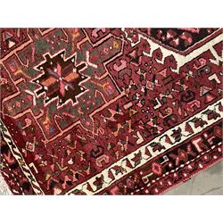 Persian Karajeh runner, red ground field with a series of eleven medallions and profusely decorated with stylised motifs, repeating guarded border