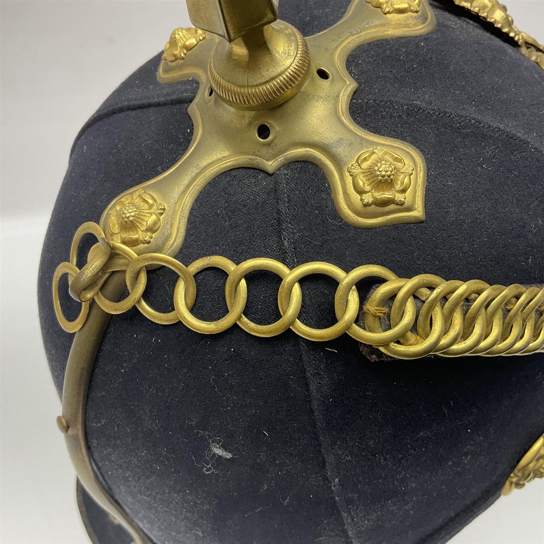 Post-1902 Welsh Regiment Officer's Home Service Blue Cloth Helmet with gilt metal King's crown helmet plate to the front, a removable spike to the top on a shaped cruciform base with rosette fittings, rosette side bosses, brass trim to the front peak, and leather and velvet backed chin scales, with sweat band, the interior with the remains of a makers label at the address 1,3 & 5 Lexington Street, Golden ? London W (presumably Hobson & Sons)