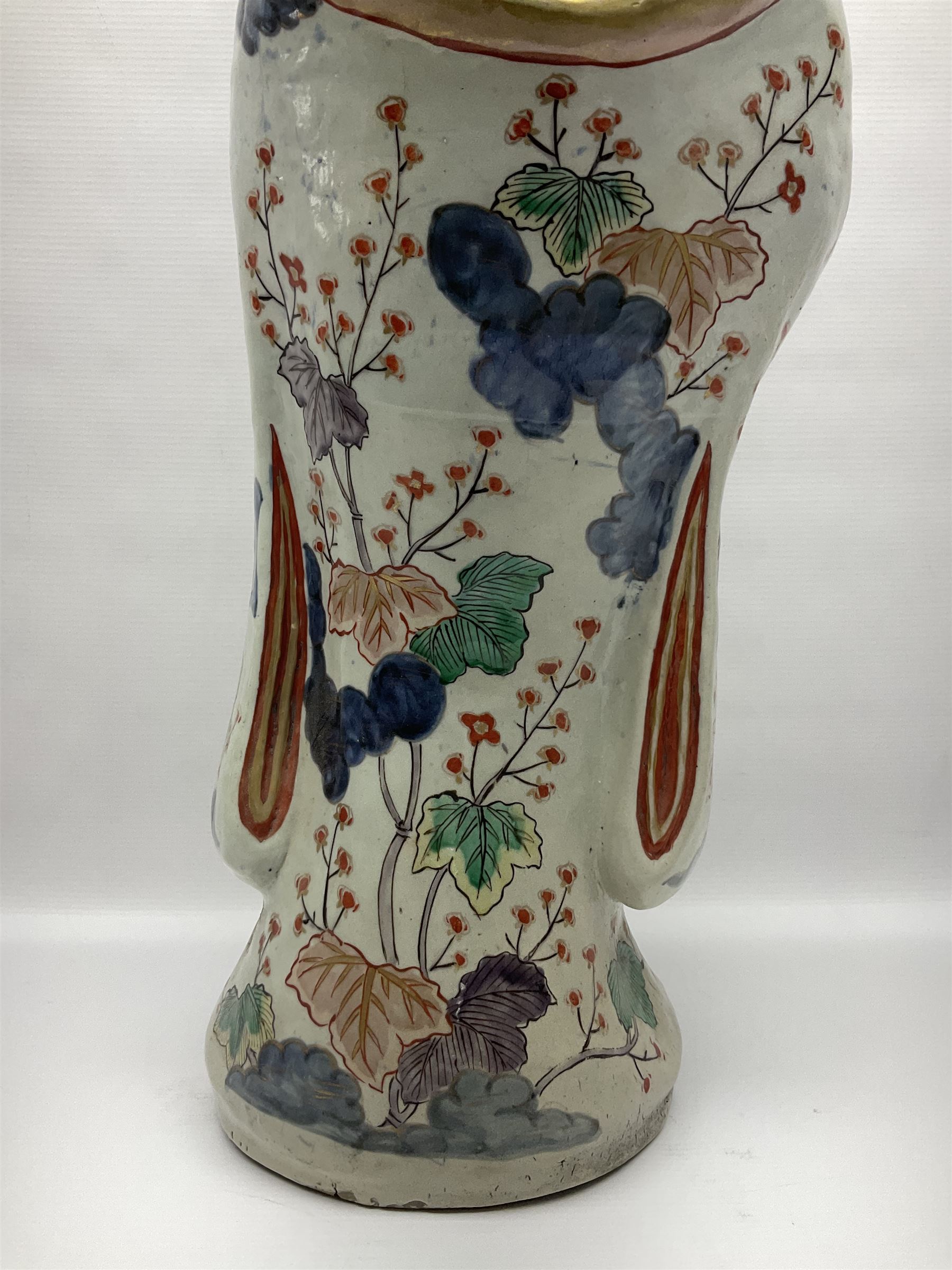 Large Japanese Imari porcelain figure, modelled as a Bijin, wearing a long kimono decorated with apple blossom and leafy branches on a white ground, with gilt detailing, possibly Edo period, H63cm