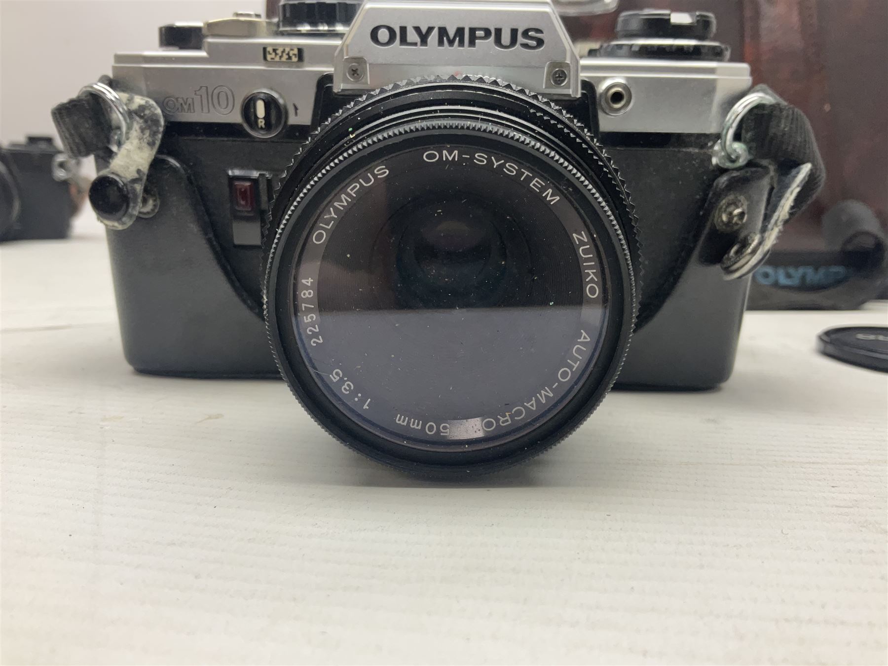 Olympus OM-2 camera body, serial no 1117526, with Olympus OM-System Zuiko Auto-W 28mm 1:2.8'  lens serial no 336591, Olympus OM10 camera body serial no 2392257, with Olympus OM-System Zuiko Auto-Macro 50mm 1:3.5' lens serial no 225784, Soligor C/D mirror lens 1:8 f=500mm' serial no 784035650 together with other camera equipment 