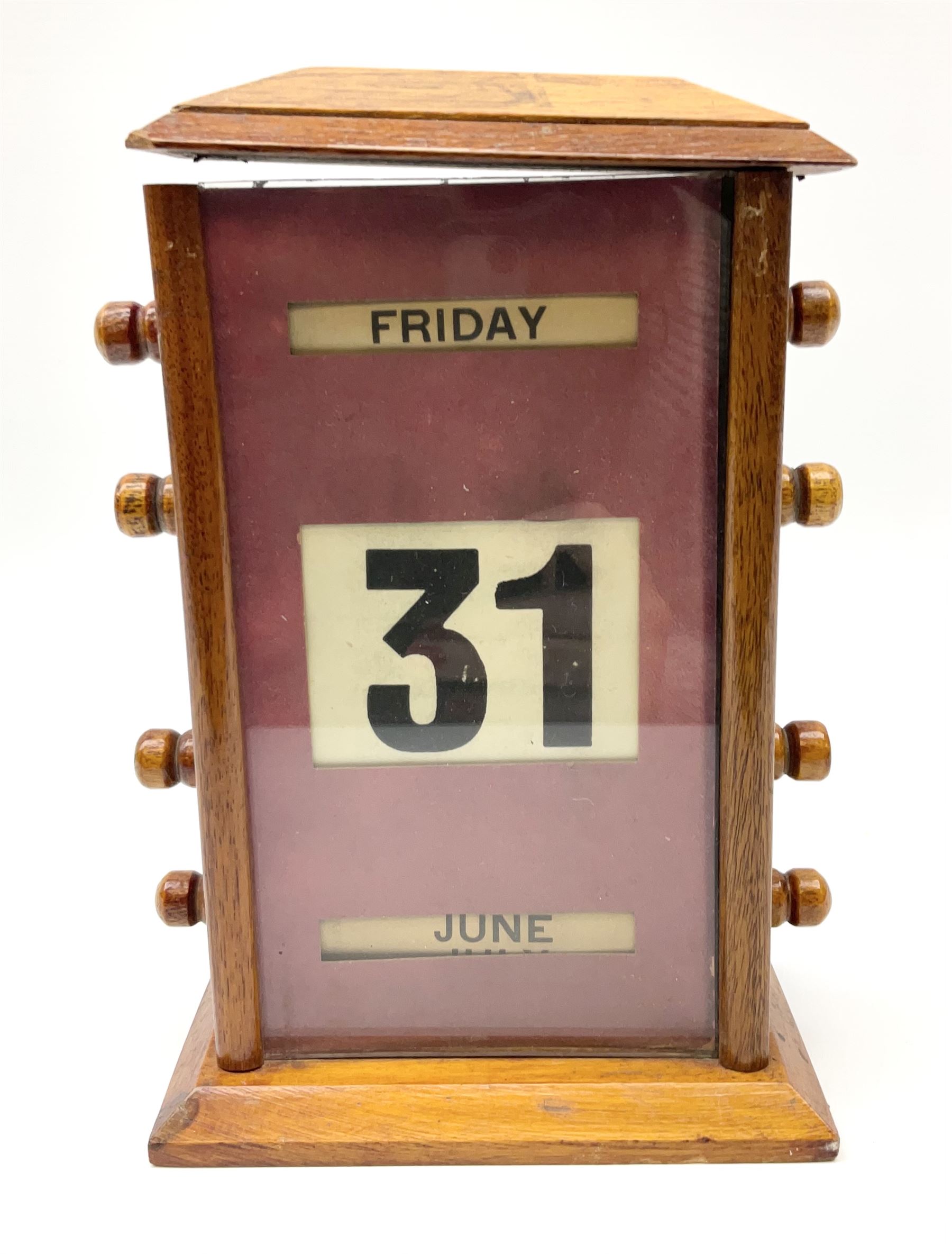 An early 20th century oak perpetual desk calendar, with three glazed apertures for day, date and month, H20cm