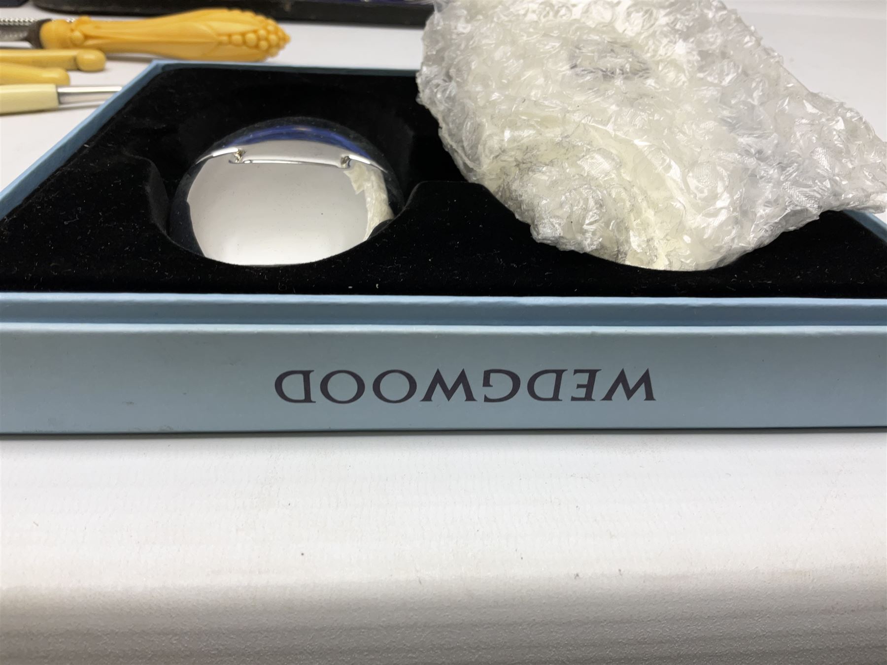 Cased pair of Wedgwood silver-plate book stands, silver-plate baby feeding spoon and pusher in box, other silver-plated cutlery