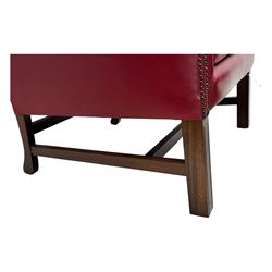 Kingsgate - contemporary 'Suffolk' wingback armchair and matching stool, upholstered in red leather with deep button tufting and brass stud trim, raised on square section supports 