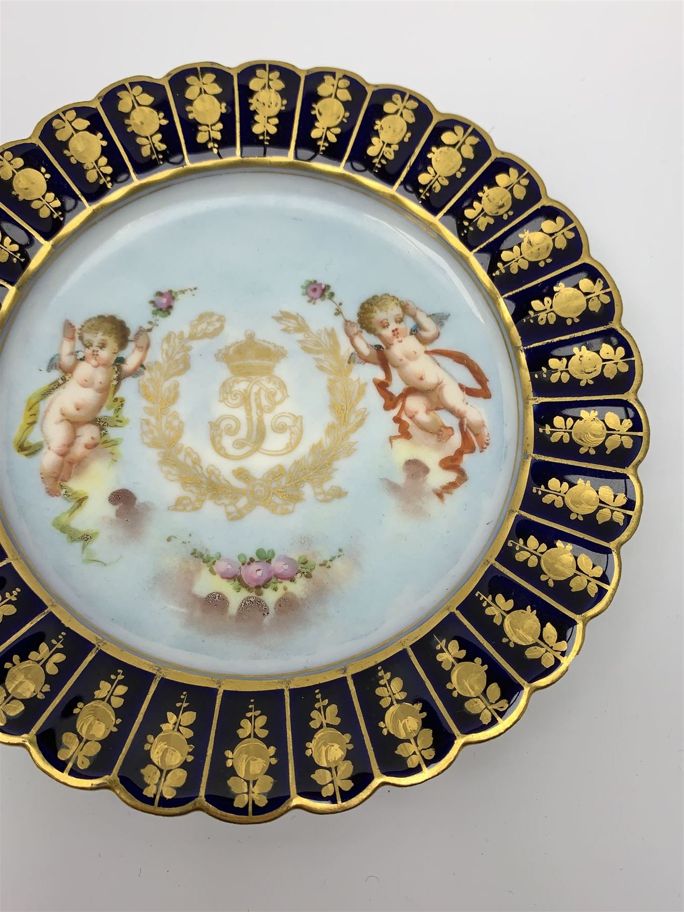 Mid 19th century Sevres Louis Philippe period porcelain cabinet plate, decorated with central Louis Philippe crowned monogram flanked by two cherubs, within cobalt gilt detailed border, with date mark for 1846, red inventory mark for Chateau des Tuileries, and blue monogram mark , D14.5cm