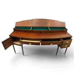 Large George III mahogany bowfront sideboard, the shaped top with raised superstructure fitted with three compartments with hinged tops and reeded edge, the body fitted with two central cock-beaded frieze drawers, flanked by a cellarette drawer and hinged cupboard both with faux double drawer facias, raised on ring turned tapering supports
Provenance: Kirkham Hall