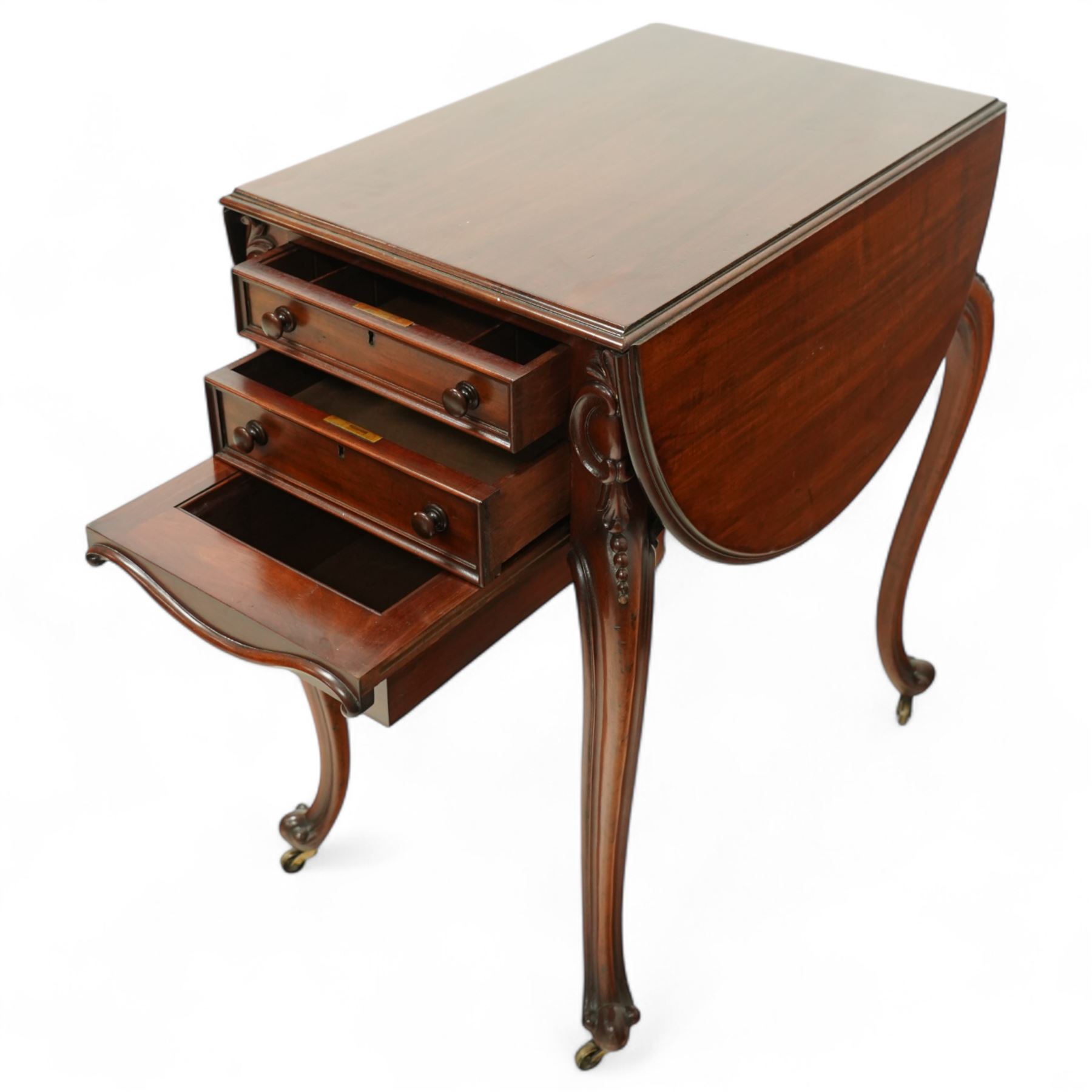 Victorian mahogany drop-leaf work table, the rectangular top with rounded hinged leaves above a bank of three drawers and opposing dummy drawers, fitted with a sliding work box, carved scroll and foliate knees, on cabriole supports with brass castors