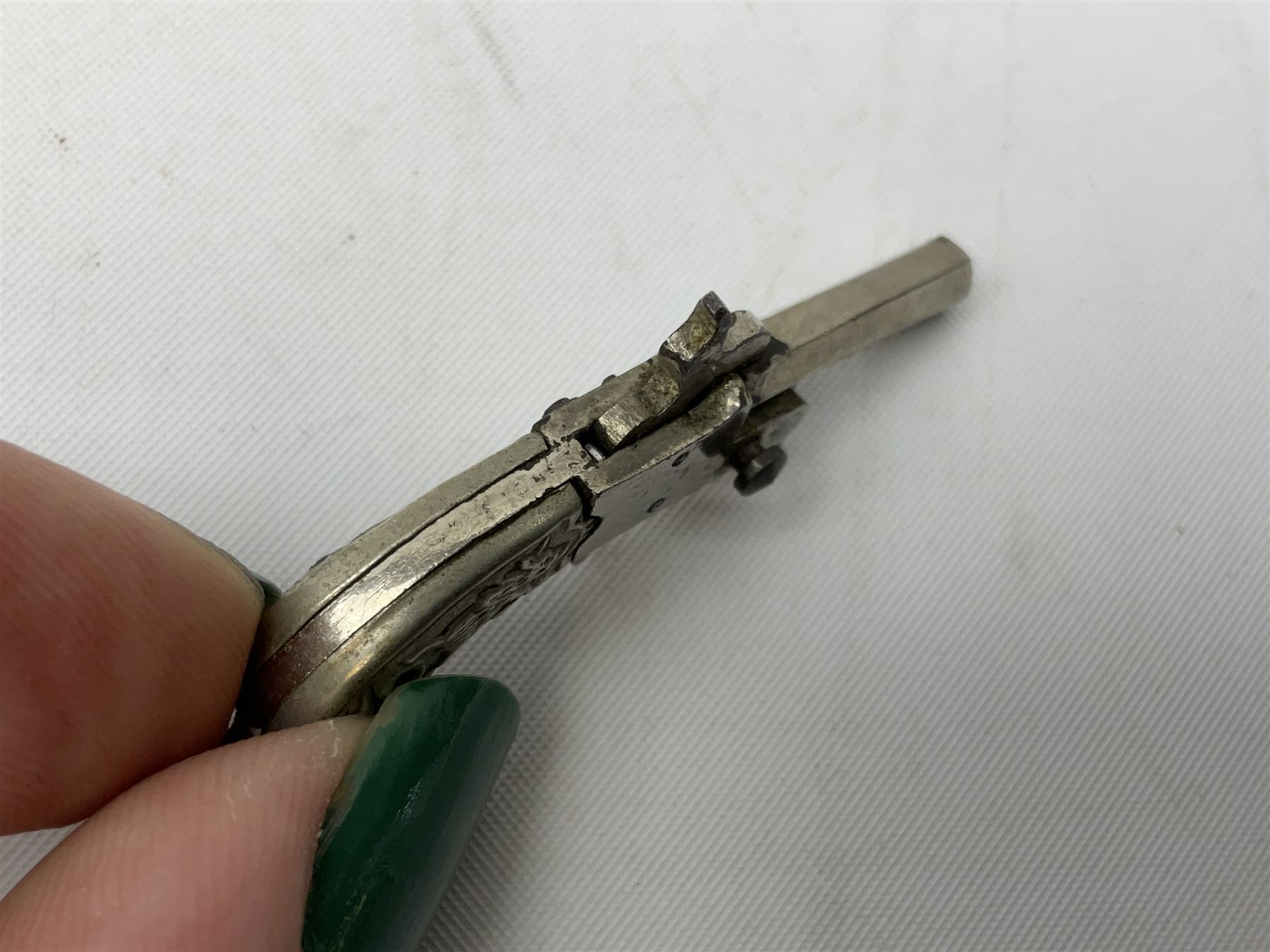 Miniature all nickel 2mm pin fire single shot pistol with engraved grip L4.5cm; together with a .925 silver half hunting cased keyless wind pocket watch inscribed 'Presented to Pte. P. Sizer By No.2 Company 1st Battalion Lincolnshire Regmt For Gallant Conduct Nr. Cork (Ireland) 31.7.20' (2)