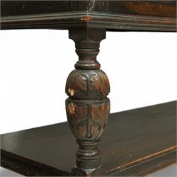 Early 20th century carved oak sideboard Jacobean style with panel back on cup and cover legs, the top section with carved panels and reeded moulding, three deep frieze drawers over triple panelled cupboard doors, raised on carved baluster legs joined by lower shelf