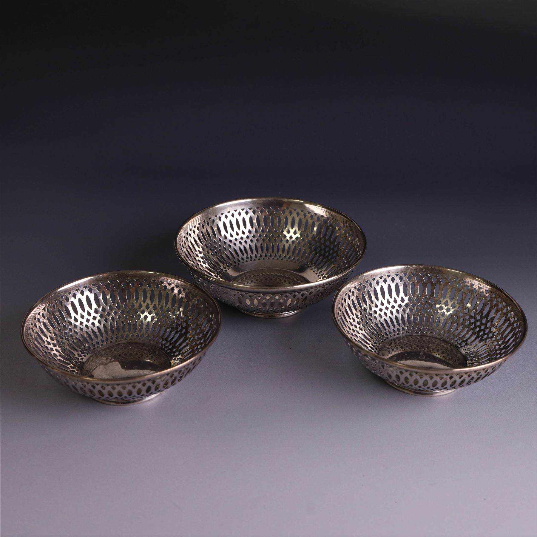 Three 1930s silver bon bon dishes, comprising pair and one larger example, each of circular form with pierced latticework sides, hallmarked Maxfield & Sons Ltd, Sheffield 1936, largest D12cm