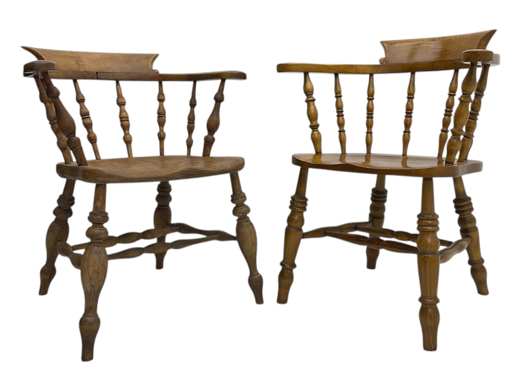 Late 19th century elm smoker’s bow armchair, curved top rails over turned spindle backs, shaped seats, raised on turned legs united by turned stretchers; together with a similar smoker’s bow armchair (2)