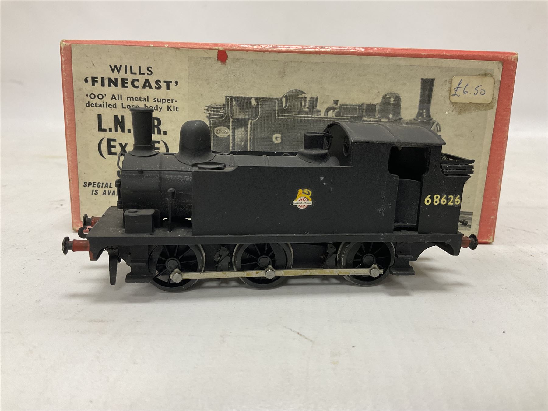 ‘00’ gauge - three steam locomotives and comprising two kit built examples; J69 Class 0-6-0T no.68619 in BR dark blue; J69 Class 0-6-0T no.68626 in BR black; with Wills Finecast boxes; one further similar example Class J67 ‘Buckjumper’ 0-6-0 no.372 being comprised of a singular heavy metal body and chassis; all models with Wills Finecast boxes (3) 