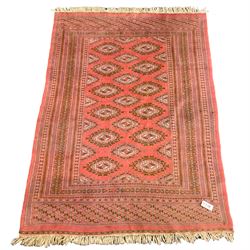 Persian pink ground Bokhara style rug, the field decorated with Gul motifs, repeating borders