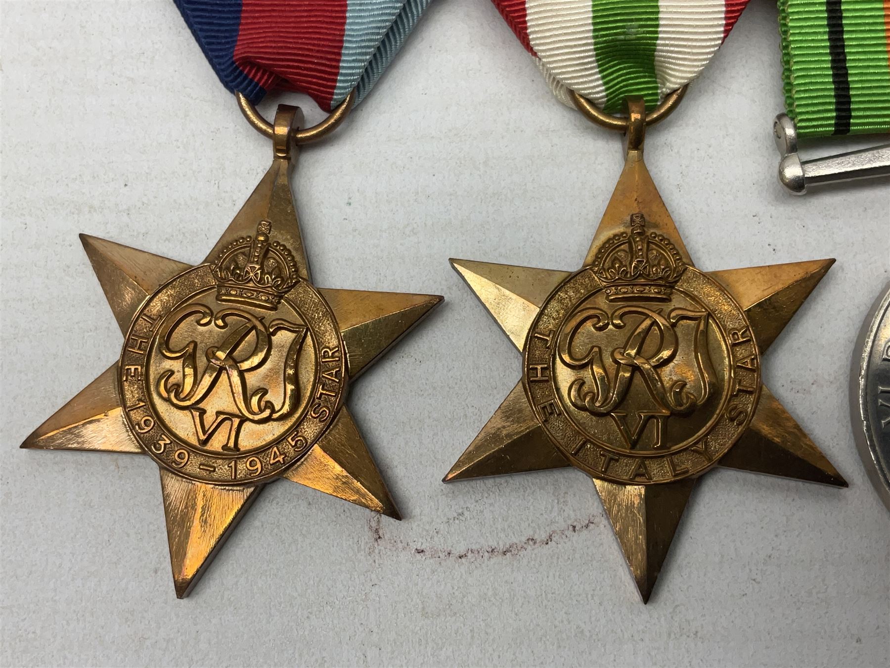 WW2 group of four medals comprising 1939-1945 War Medal, Defence Medal, Italy Star and 1939-1945 Star; with Royal Army Service Corps cap badge and RASC chrome and enamel sweetheart brooch