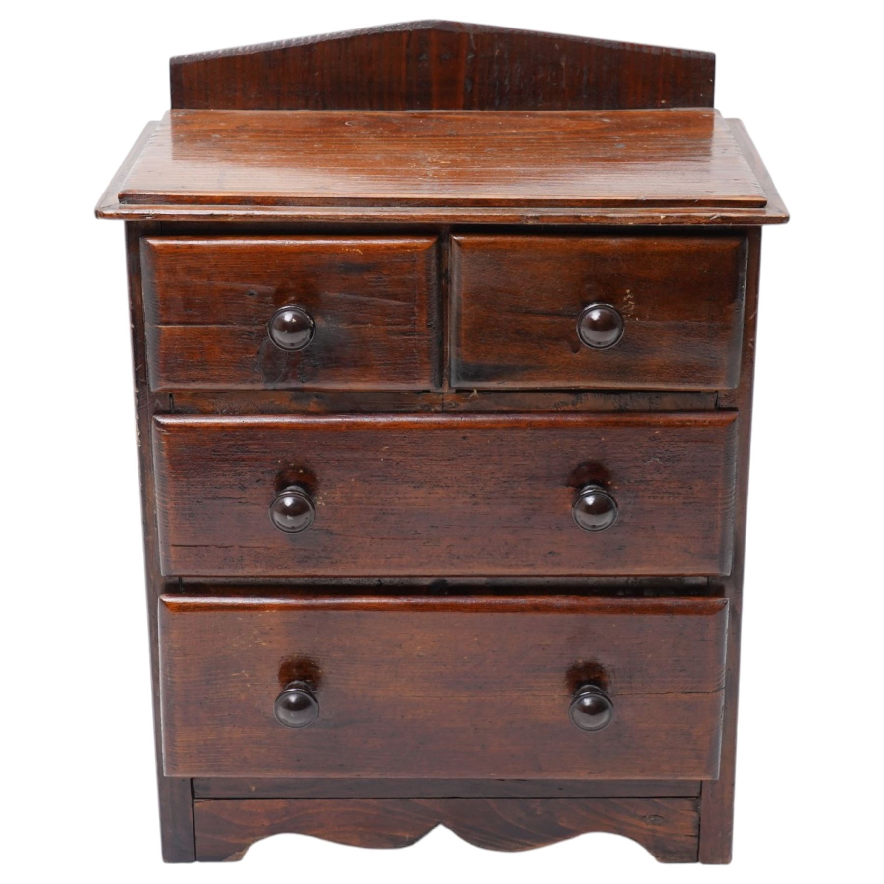 Miniature stained pine chest of two long and two short drawers above a shaped apron W28cm
