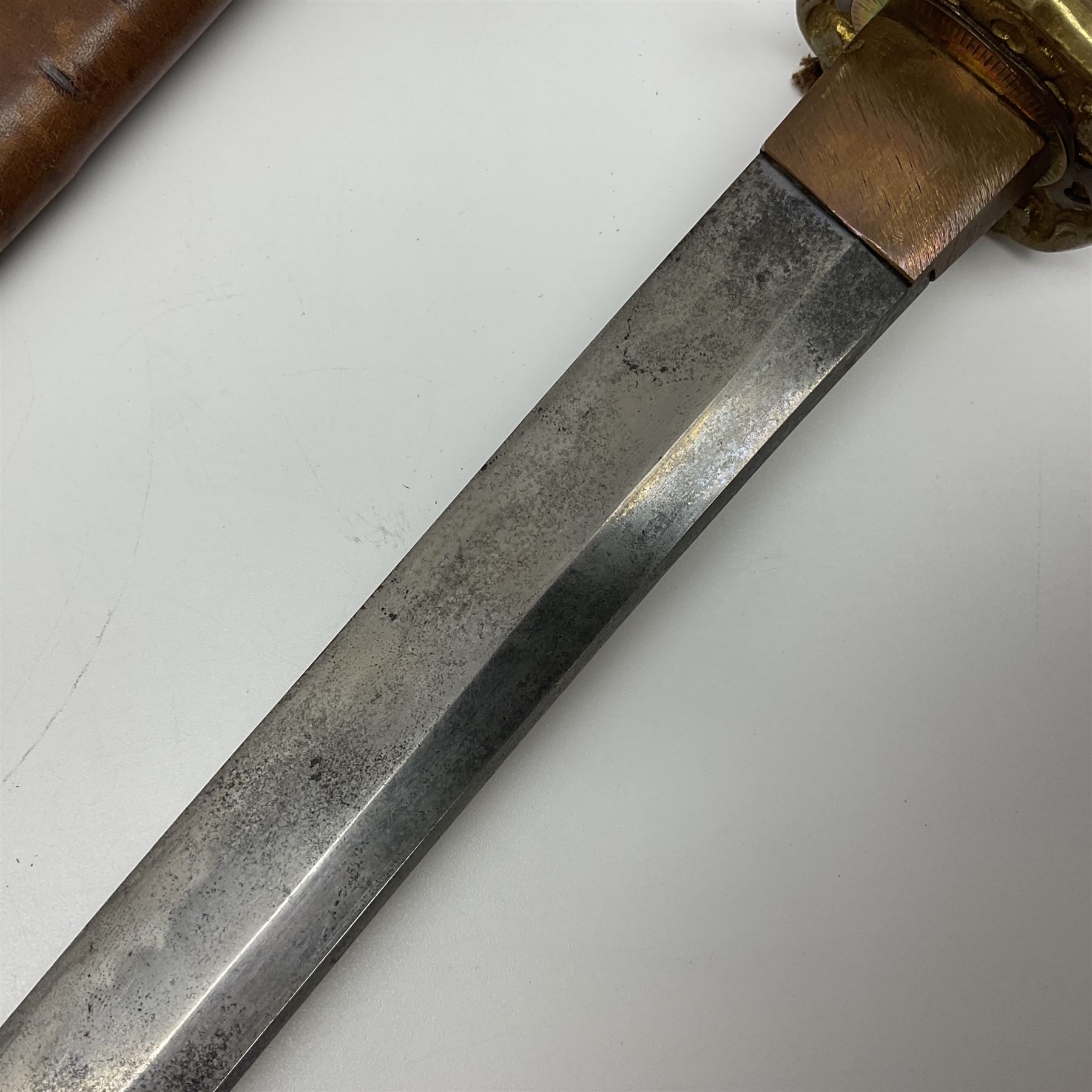 WW2 Japanese Army officer's shin gunto/katana sword with 67cm steel single edged blade, foliate cast brass tsuba, bound fish-skin grip with brass mounts, inscribed and painted marks to tang; in lacquered wooden scabbard with leather combat covering bearing four character marks L99cm overall