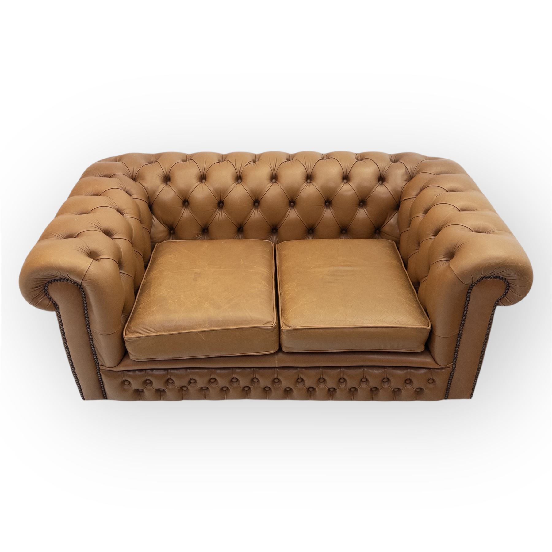 Contemporary tan leather chesterfield settee, deep button upholstered throughout with rolled arms and back of equal height, brass stud detailing, twin seat cushions
