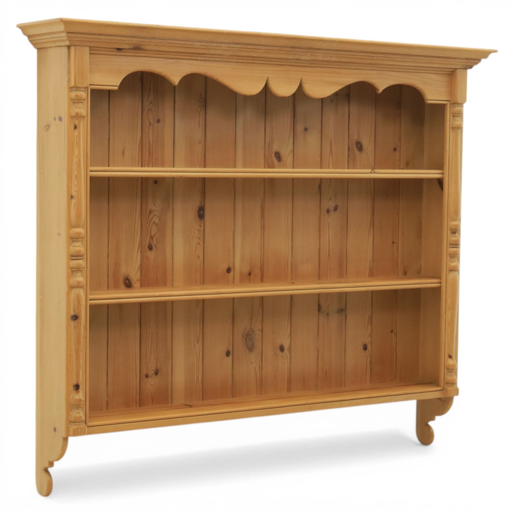 20th century country style waxed pine hanging wall shelf, with projecting cornice, over three fixed delf racks, flanked by applied turned columns, with brass wall hangers