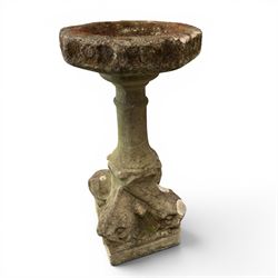 19th century weathered sandstone birdbath, the octagonal canted dished top raised on a ring turned flared pedestal, with four carved stylised dolphins to the squared base