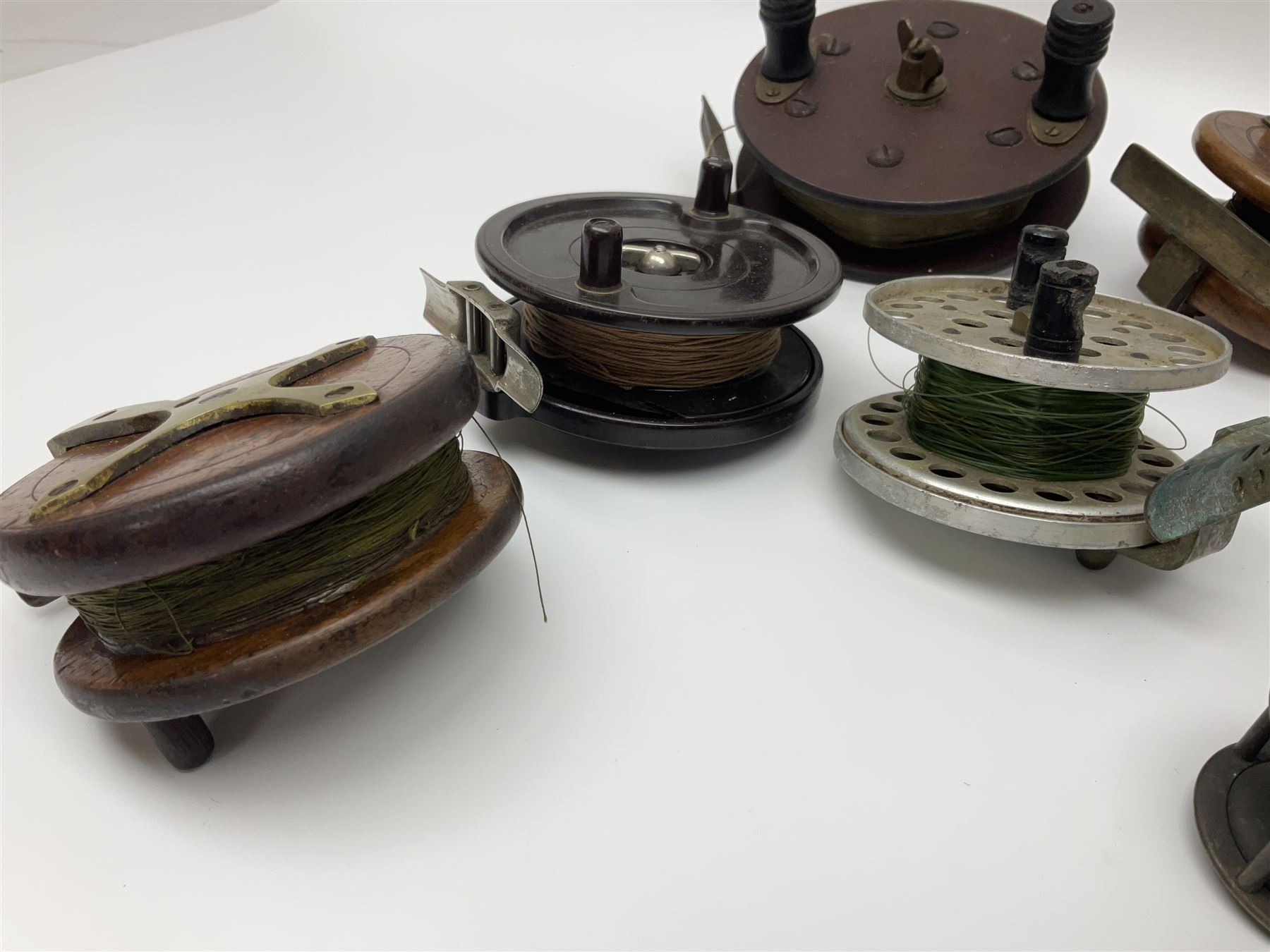 Six early 20th century fishing reels, to include wooden and brass examples, together with a leather powder flask, 1913 Christmas tin, Morgan dollar, Queen Victoria double florin and a collection of other coins, etc 
