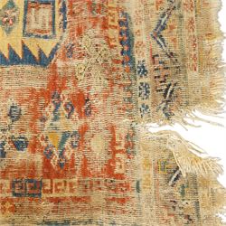 Antique Caucasian crimson ground carpet. the field decorated with three geometric indigo medallions with surrounding geometric motifs and guard lines