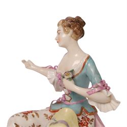 Pair of 19th century Samson figures, the gentleman wearing a wide brimmed hat with a dog, the lady with a sheep by her side, both figures seated upon a floral encrusted pillars with gilt scrolling base, H22cm
